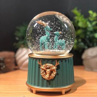Pilli Işıklı Müzikli Kar Küresi–İki Geyikli Yeşil Figürlü Eğlenceli Masaüstü Biblo, LED Aydınlatmalı Dekoratif Hediyelik Kar Küresi